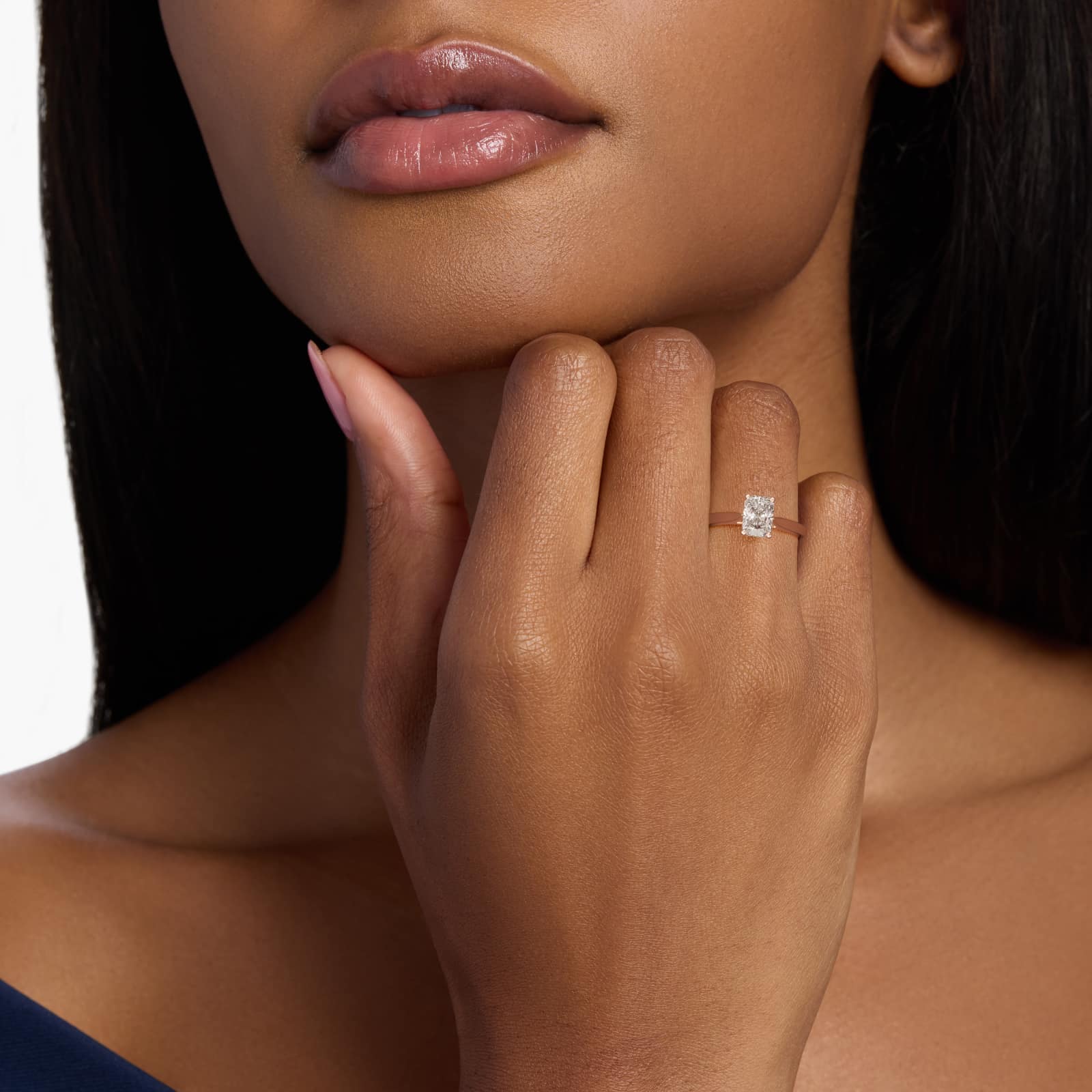 A hand wearing a luxurious 3 carat radiant cut lab grown diamond ring with a D-IF center stone in a yellow gold solitaire setting.